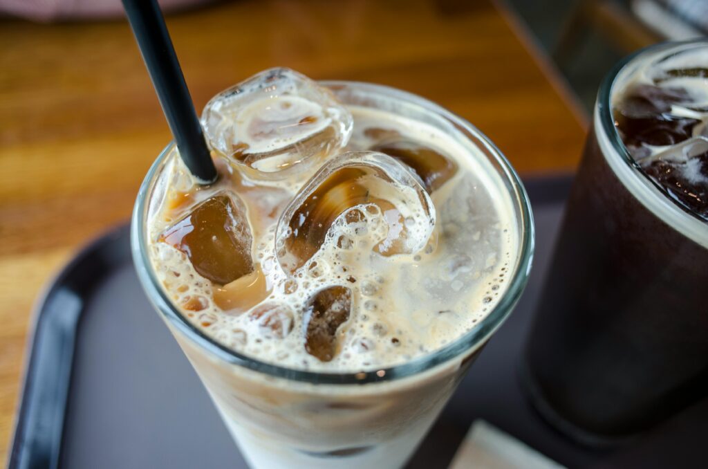 Close-up of a delicious iced milk tea with visible ice cubes and a straw.